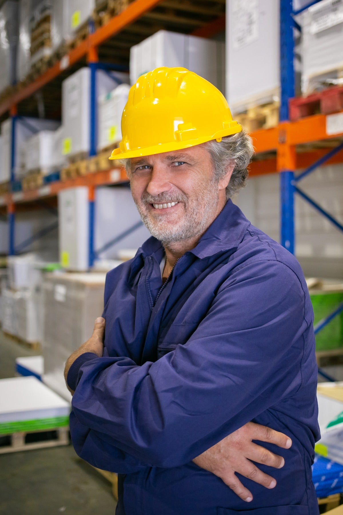 Lavoratore sorridente con elmetto in magazzino